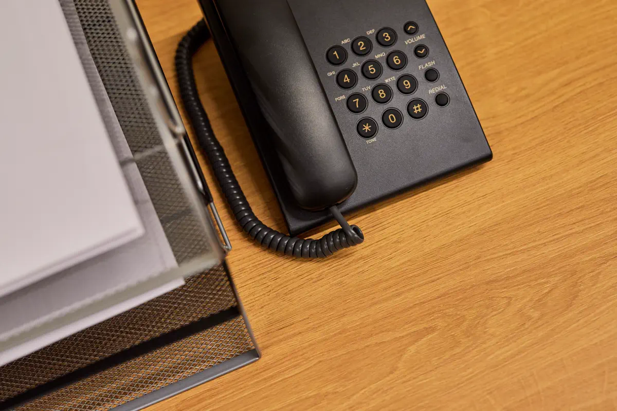 Office telephone beside an organizer filled with paper files