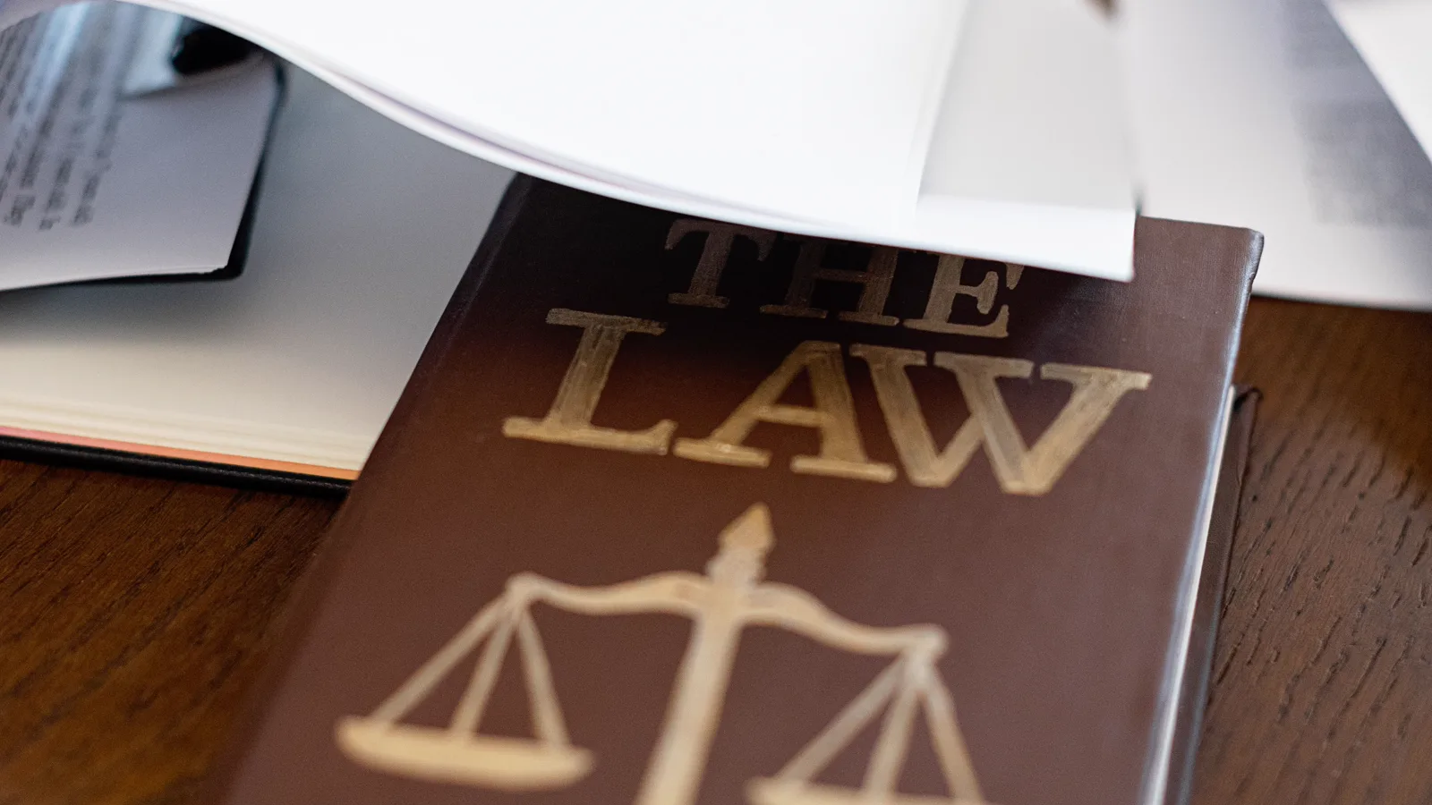Law book and case papers arranged on a wooden desk
