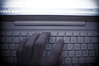 hand typing on a computer keyboard - search warrants child pornography law