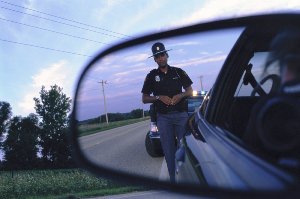 DUI Traffic Stop - Priest Criminal Defense - Lawyer Vancouver Washington - picture of a cop in rearview mirror